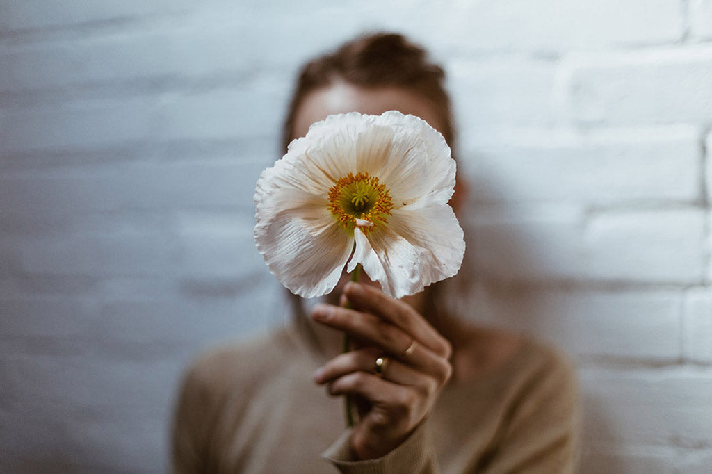 Girl holding poppy flower showing pollen