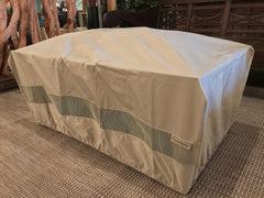 A rectangular shaped IMPACT Fire Table with a khaki colored polyester cover.