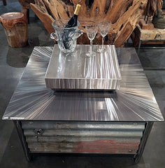 A square IMPACT Fire Table with a hand brushed stainless steel firebox cover installed
