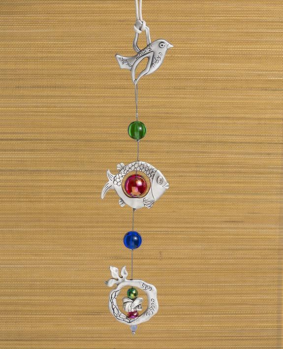 A delicate and beautiful hanging wall ornament, bringing together a few blessing motifs: a bird, a fish and a pomegranate, all hanging from a subtle silver string. The ornament is coated in sterling silver and is decorated with colorful beads. The bird and pomegranate are engraved with words of blessing for harmony, luck, success, stability, and joy. Makes a charming gift for any occasion and for anywhere in the house or office. It's so pleasant to gaze at this lovely ornament and smile every moment with gr