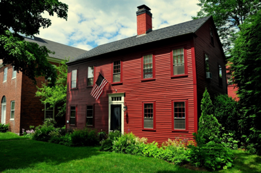 Traditional colonial red exterior and trim with cream front door trim and black door