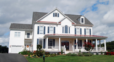 traditional white colonial house with red accent features 