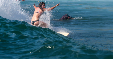 Surfer Wearing Hakuna Wear Kare Kare Athletic Bikini Top