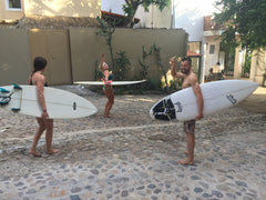 surfers walking to surf