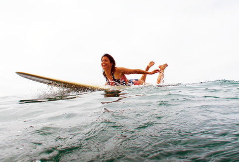 Woman paddling for a wave