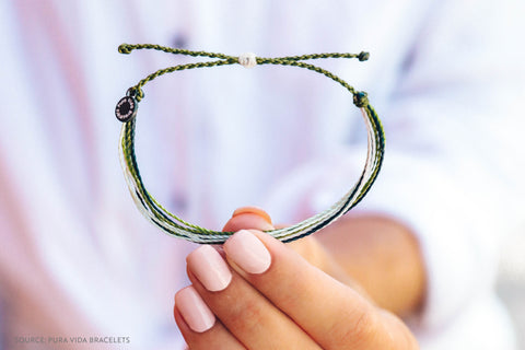 Pura Vida Bracelets Model Holding a Grey Charity Bracelet - sweetsherriloudesigns Blog - 7 Eco-friendly Companies That Give Back To The Planet