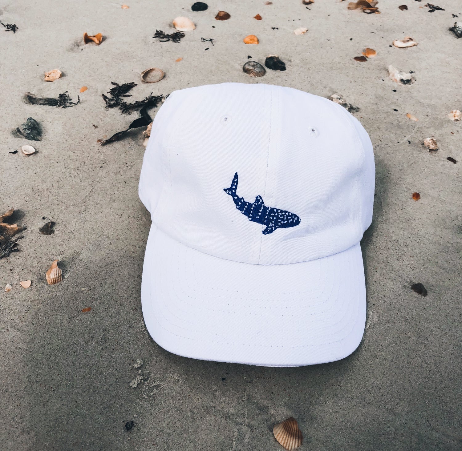 getpinkfit Whale Shark Embroidered Cotton Cap on a beach - 10% of profits donated to Mission Blue ocean conservation efforts - ethically and sustainably made clothing