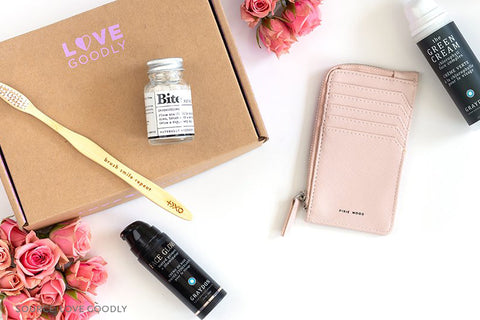 Love Goodly Box with Items Surrounding It, Bamboo Toothbrush, Vegan Leather Wallet, and Face Products - sharonkornman Blog - 7 Eco-friendly Companies That Give Back To Our Planet