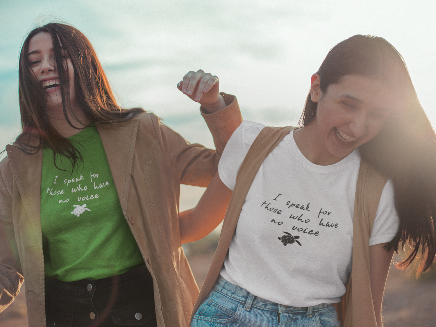 Two girls laughing wearing matching getpinkfit green and white colored Be The Voice Sea Turtle Short-Sleeve Tees