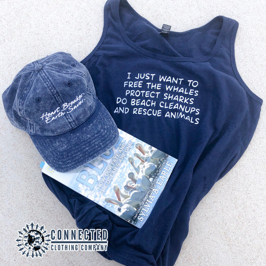 Navy Blue I Just Want To Save The World Women's Relaxed Tank Top on the beach sand with Heart Breaker Earth Saver Cotton Cap and Mission Blue book. - getpinkfit - Ethically and Sustainably Made - 10% donated to Mission Blue ocean conservation