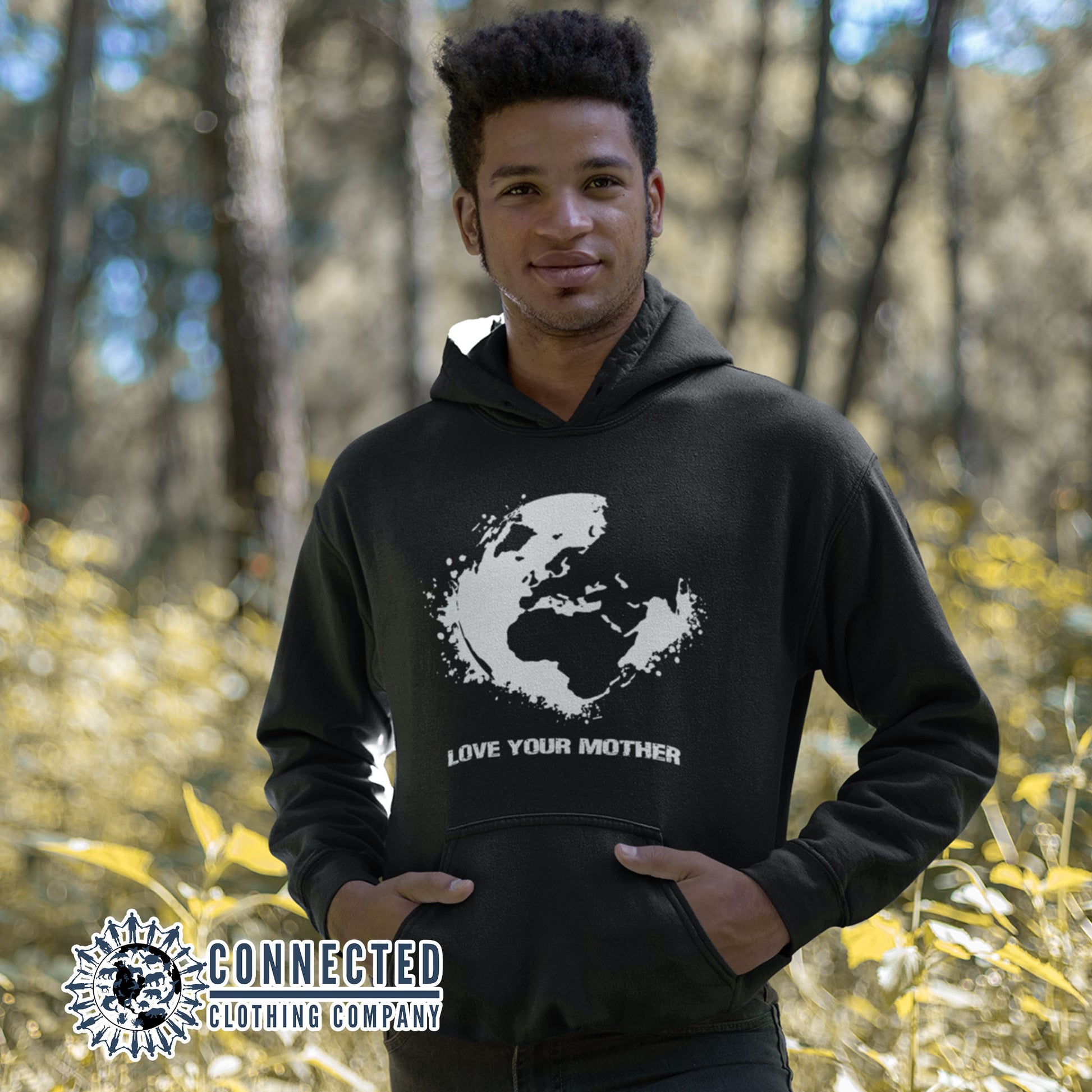 Model in the forest wearing Black Love Your Mother Earth Unisex Hoodie - sweetsherriloudesigns - Ethically and Sustainably Made - 10% donated to the Environmental Defense Fund