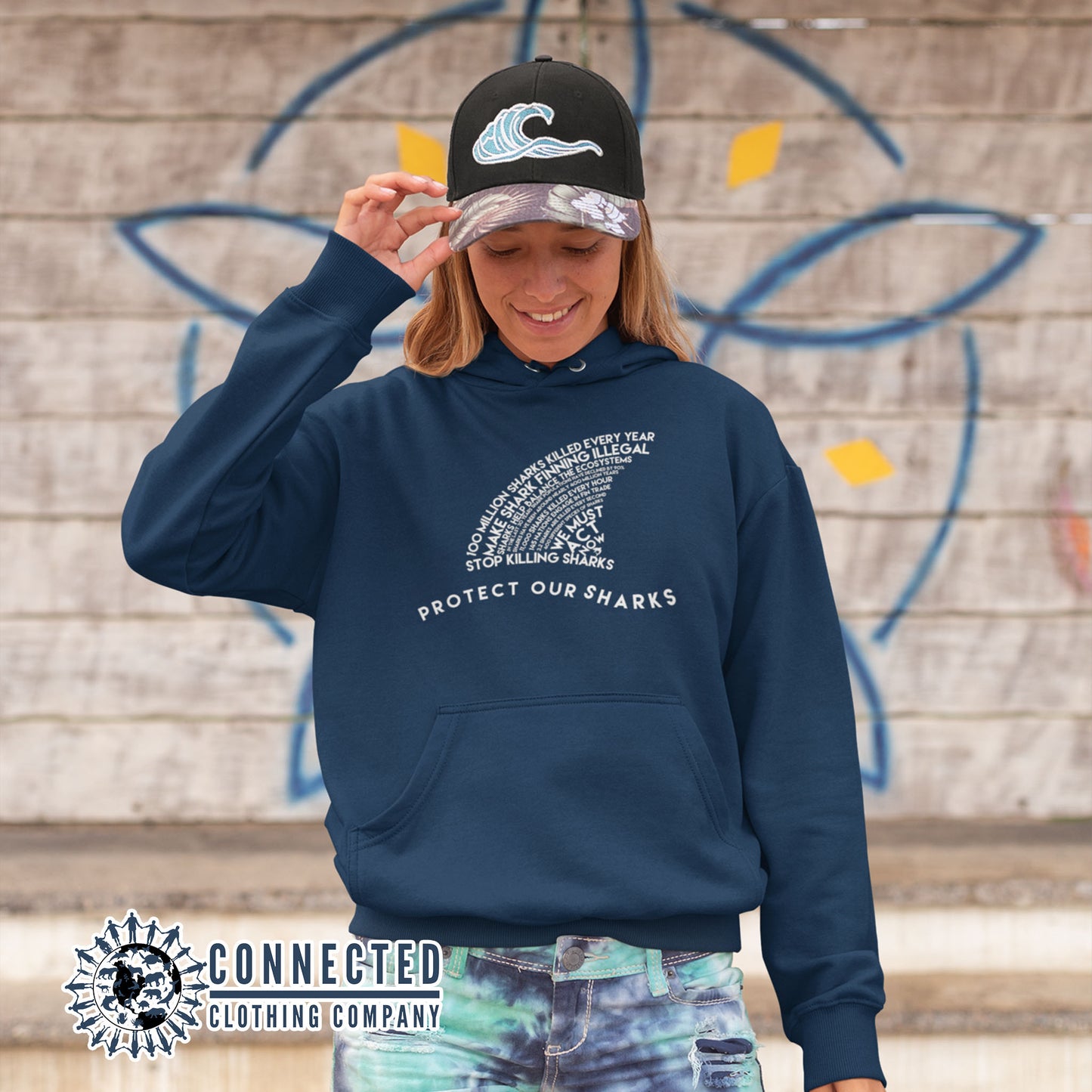 Model Wearing Navy Protect Our Sharks Unisex Hoodie - sweetsherriloudesigns - Ethically and Sustainably Made - 10% donated to Oceana shark conservation