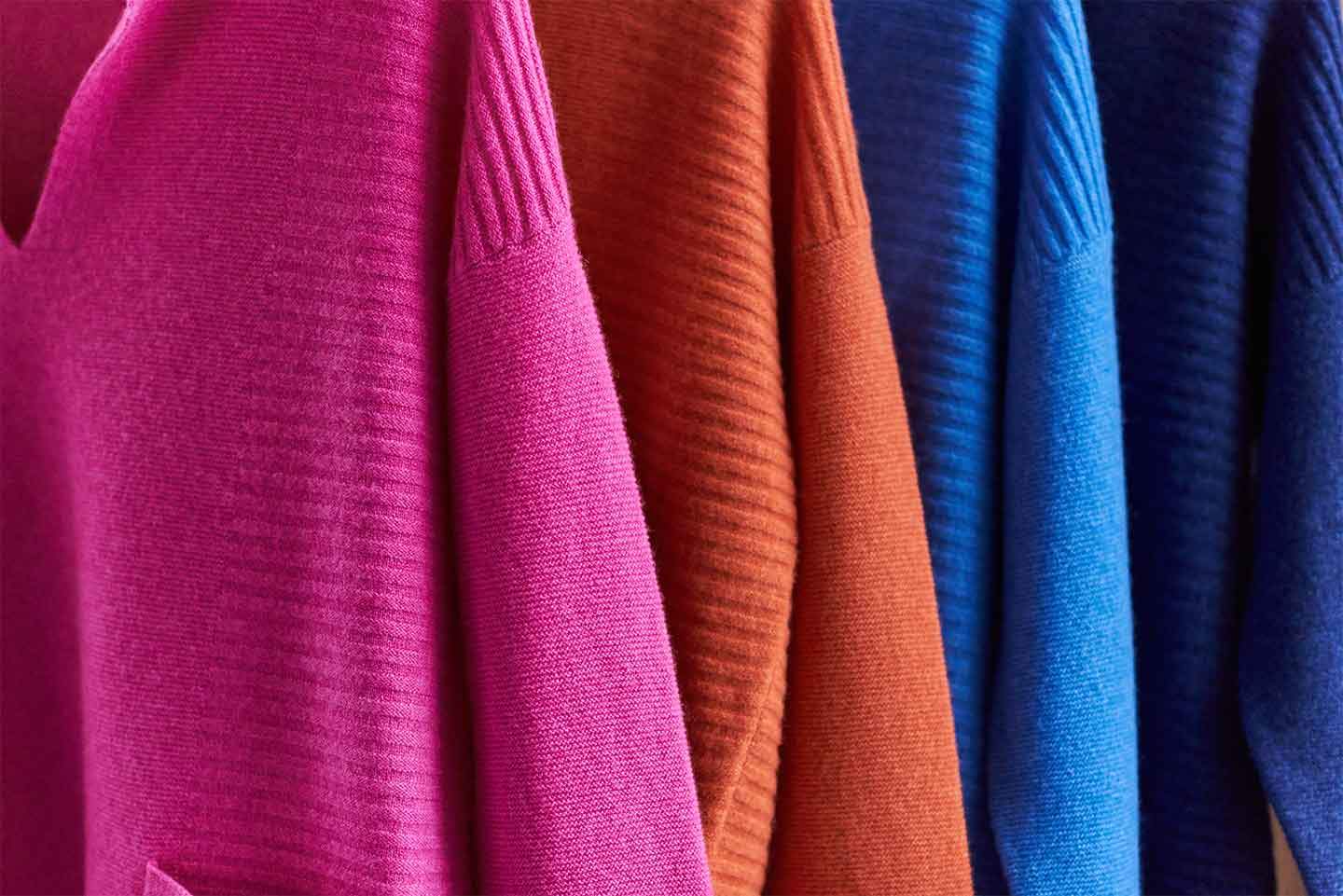 Cashmere jumpers in a range of colours hanging 