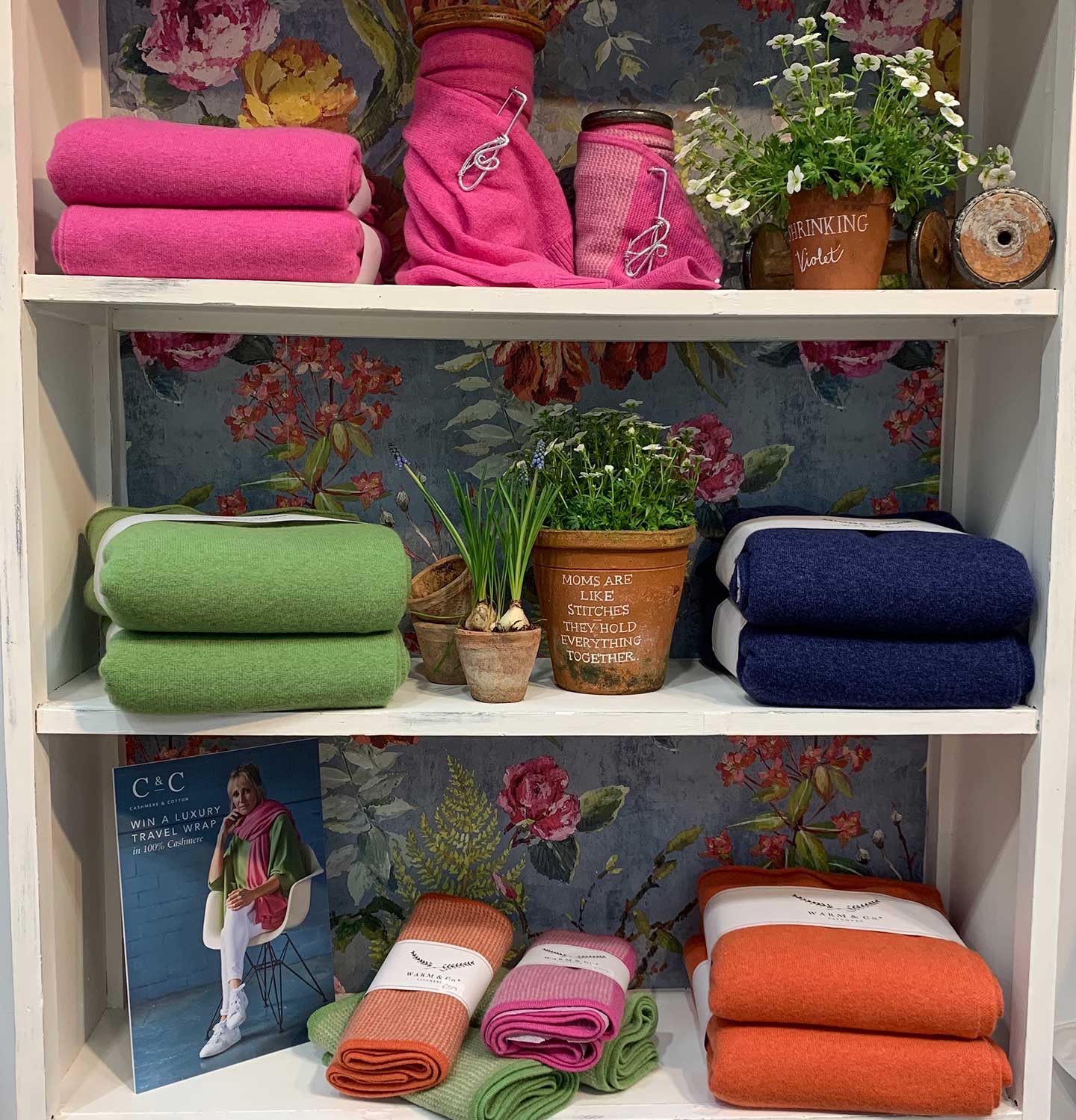 bright summer cashmere on shelves with flowers and floral background
