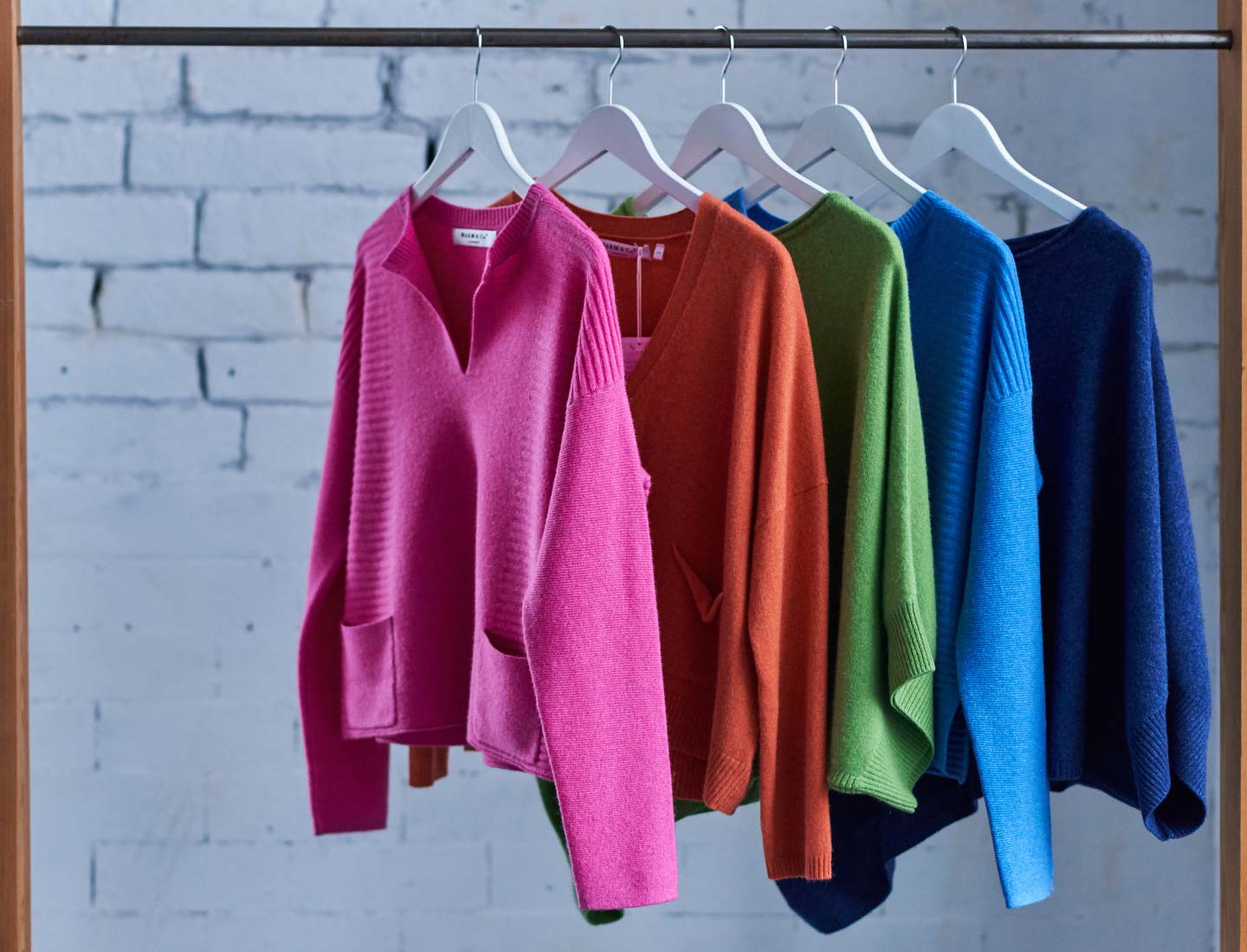 cashmere-jumpers-on-a-wooden-rail-in-a-warehouse