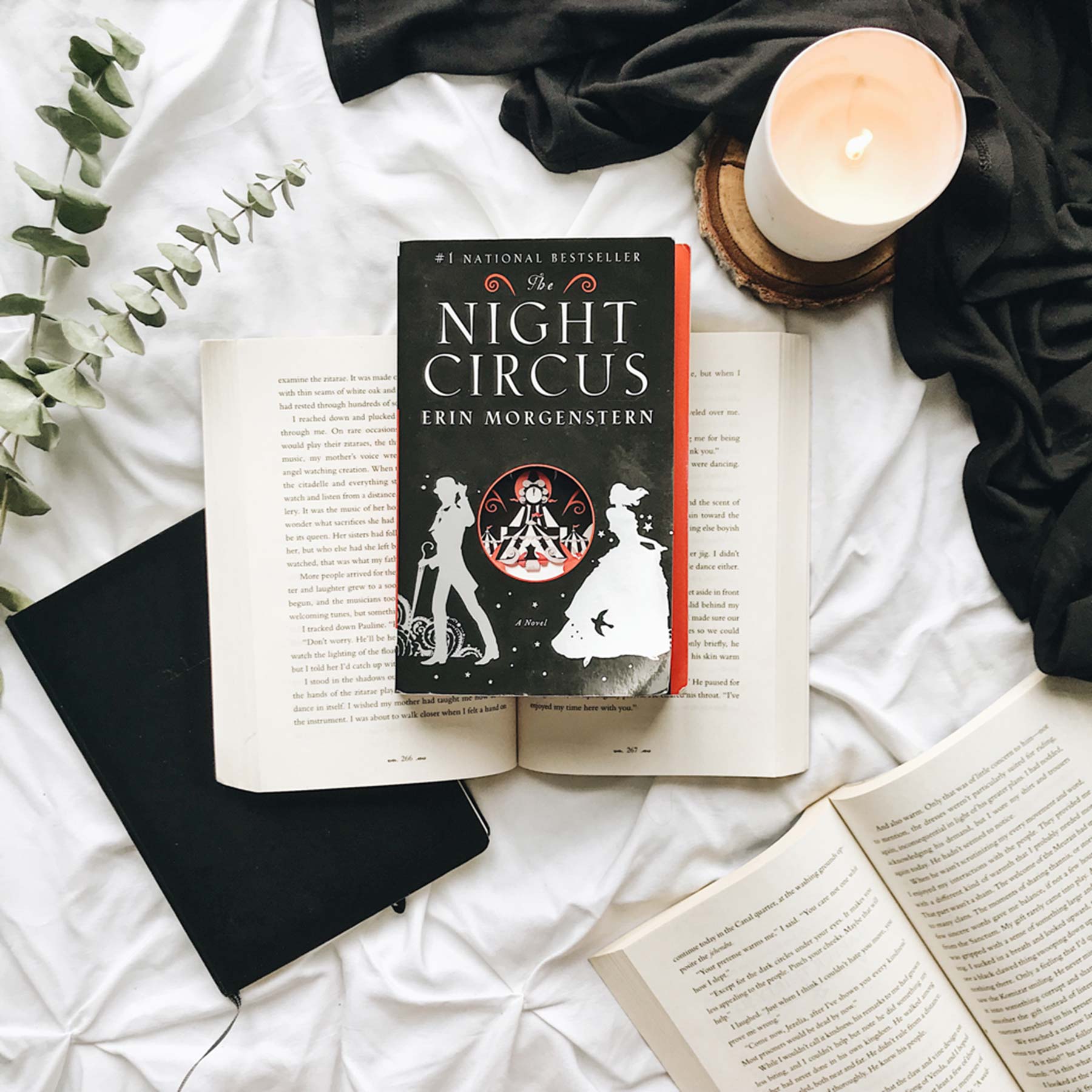 the night circus reading book on a bed by candle light