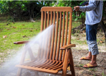 someone cleaning a chair outside