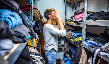 someone searching through a cluttered closet