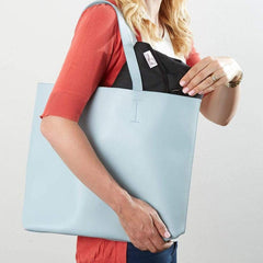 The wriggler anti roll changing mat folded and being placed in a handbag