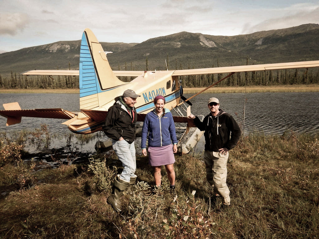 ultralight backpackers pose with pilot in front of small plane