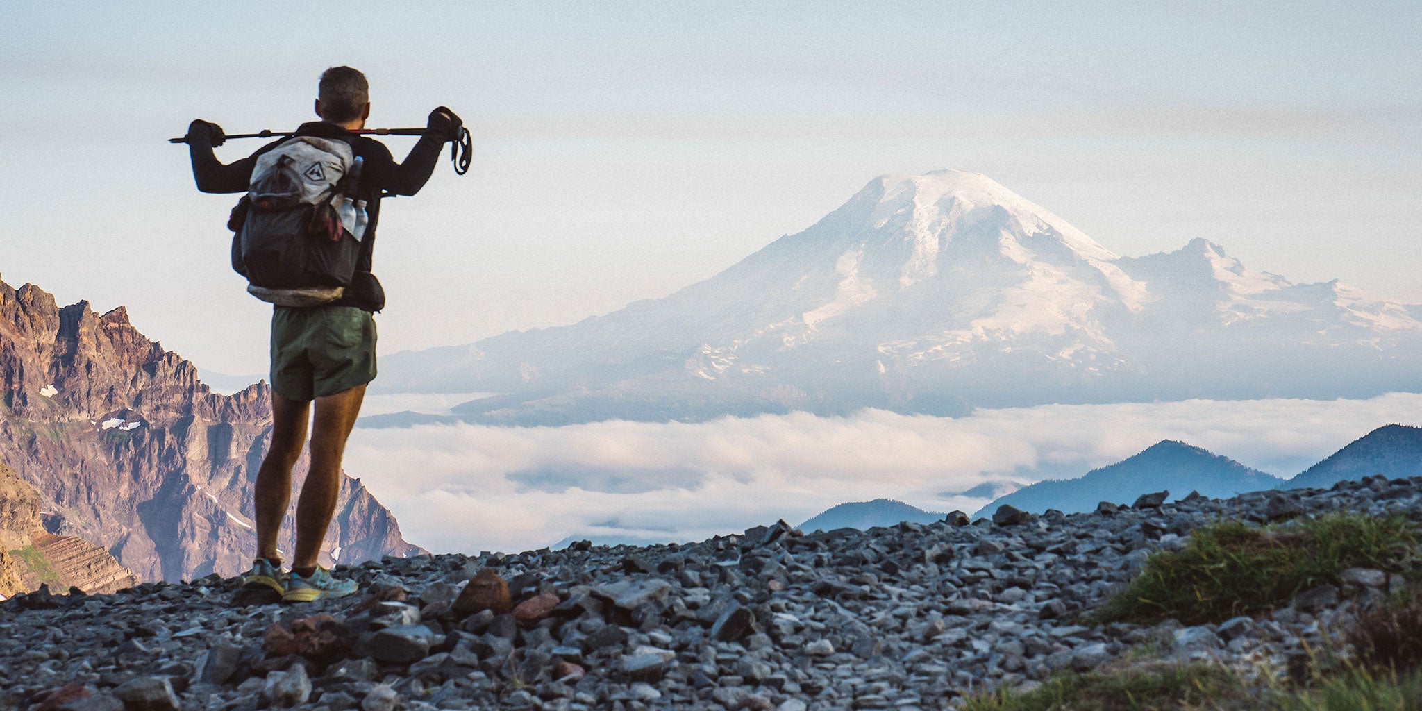 Ultralight backpacker looks towards a looming mountain