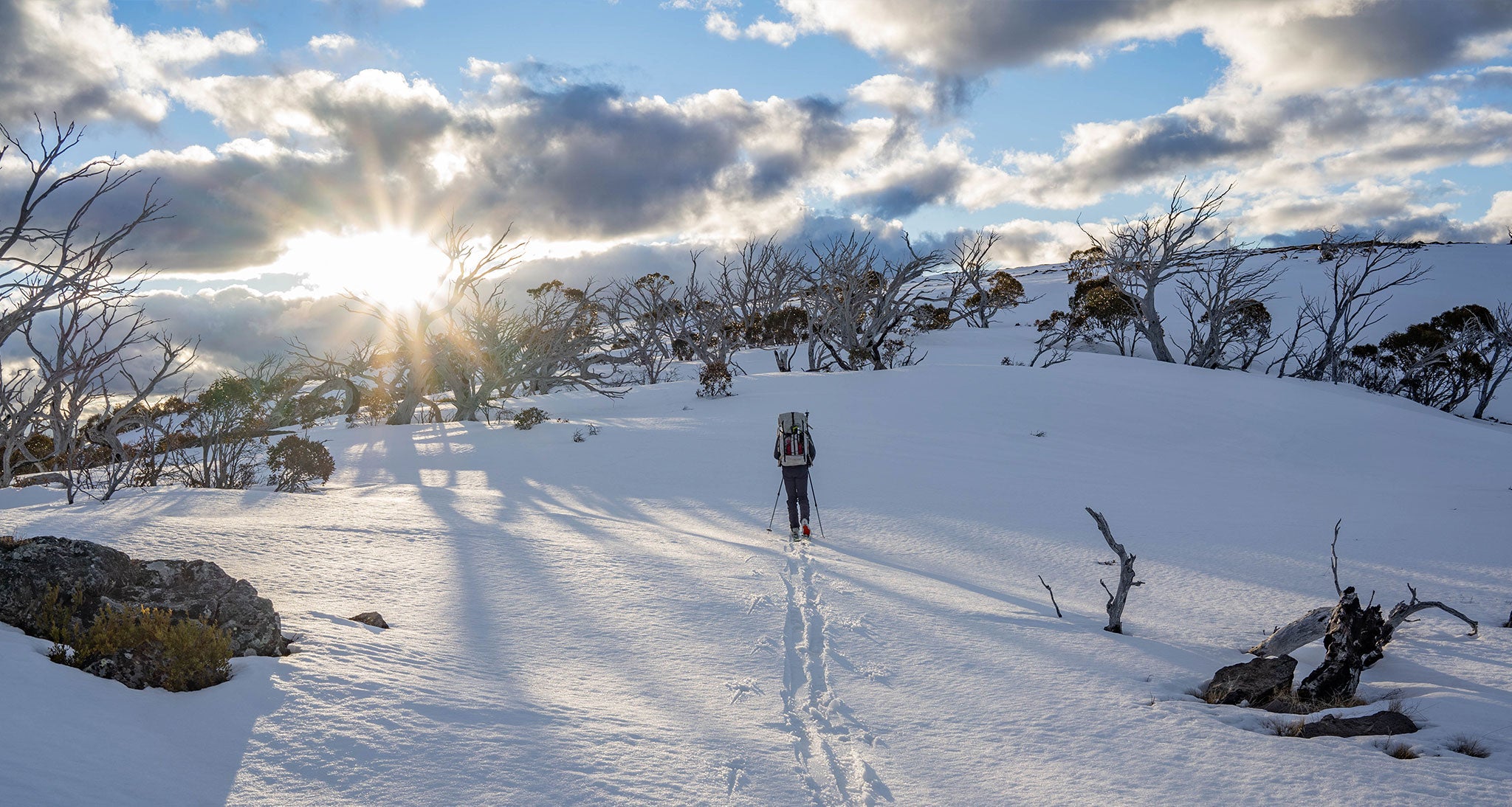 Ultralight backpacker hiking up snowy mountain