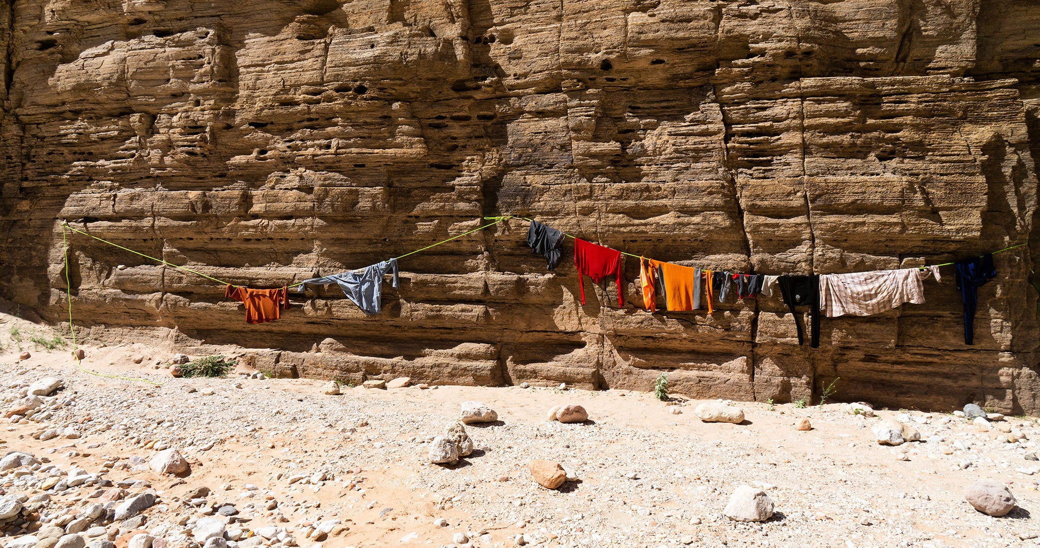 Hiking clothes hanging on a makeshift clothesline made of guy line