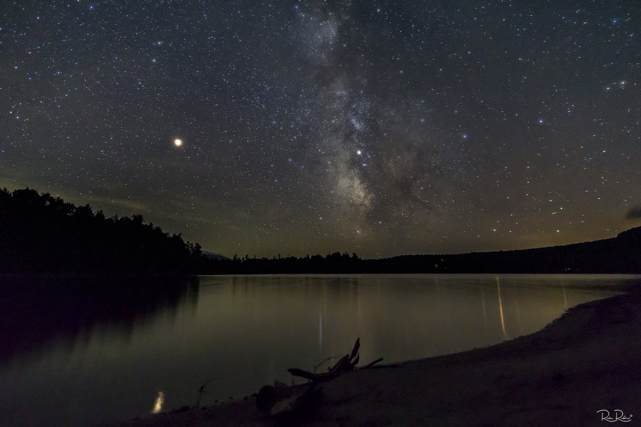 Starry night sky over a lake in Maine