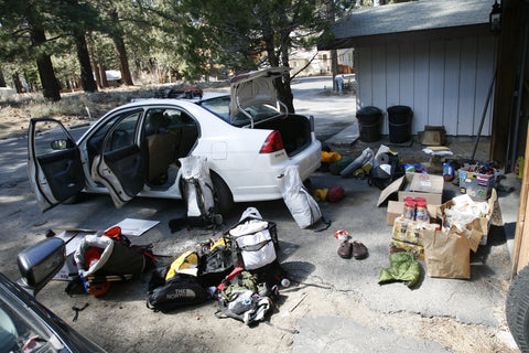 Ultralight backpacking gear spread around a car