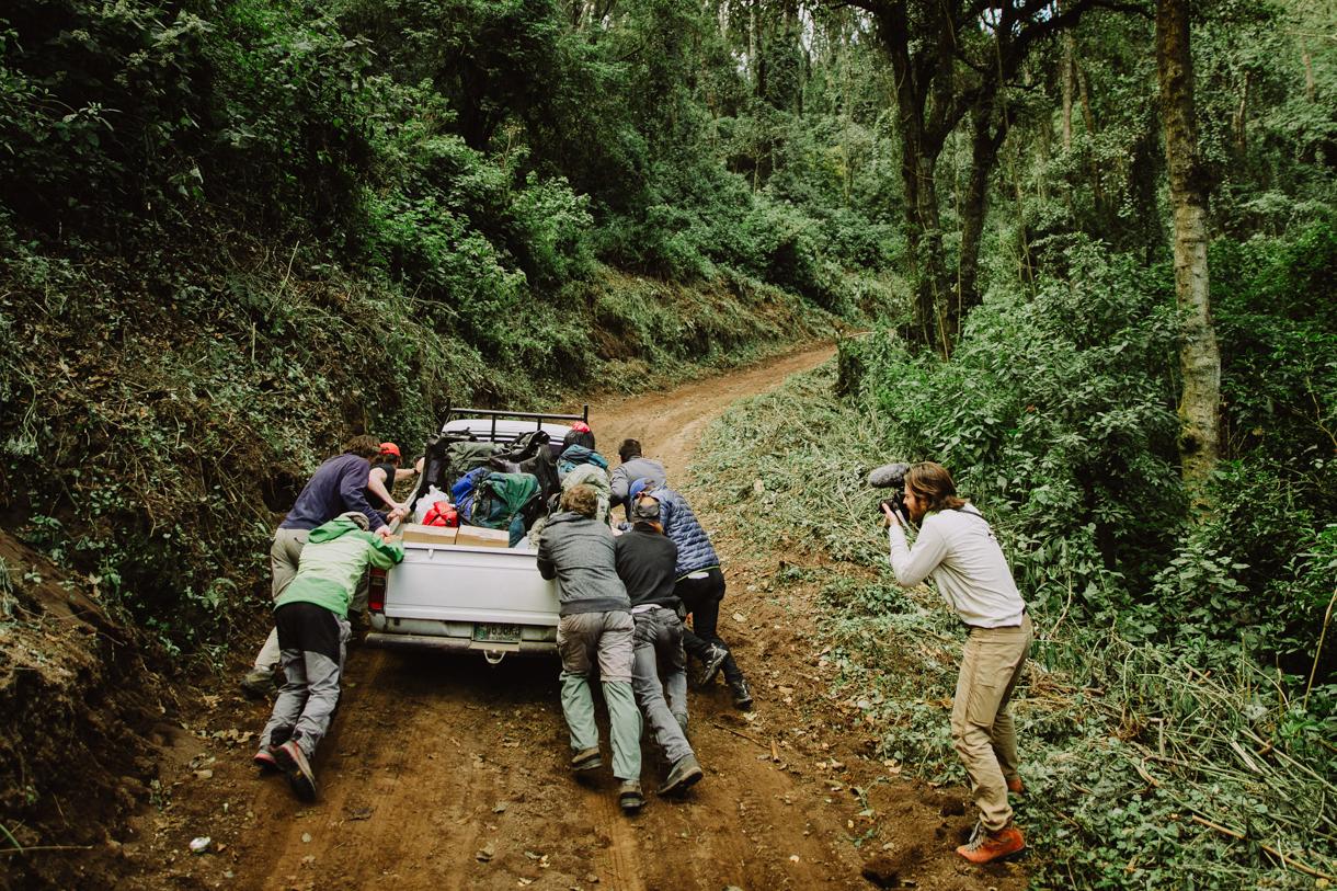 Group of people pushing a truck out of mud