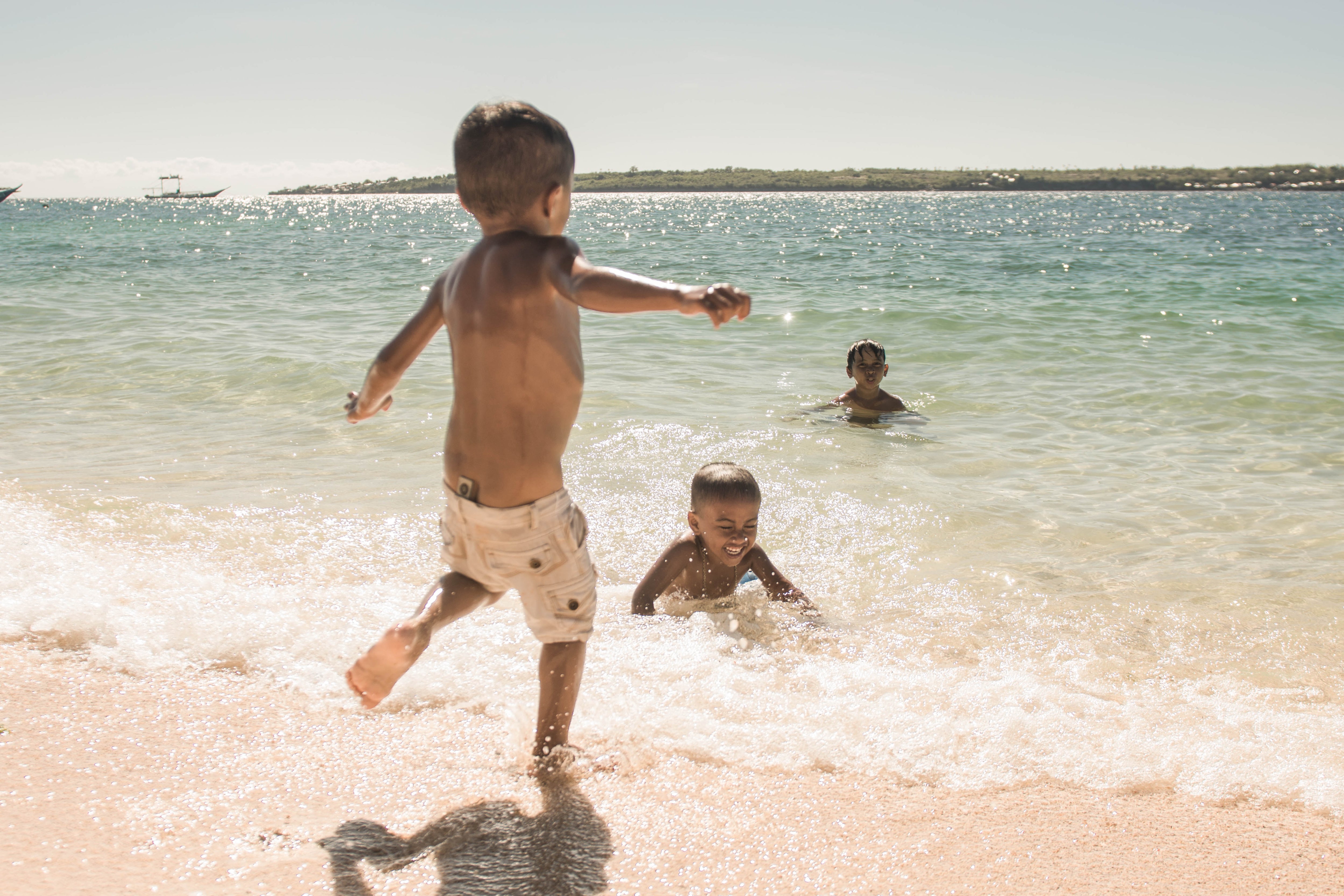 Little Boys Playing in the Ocean Laughing and Having Fun