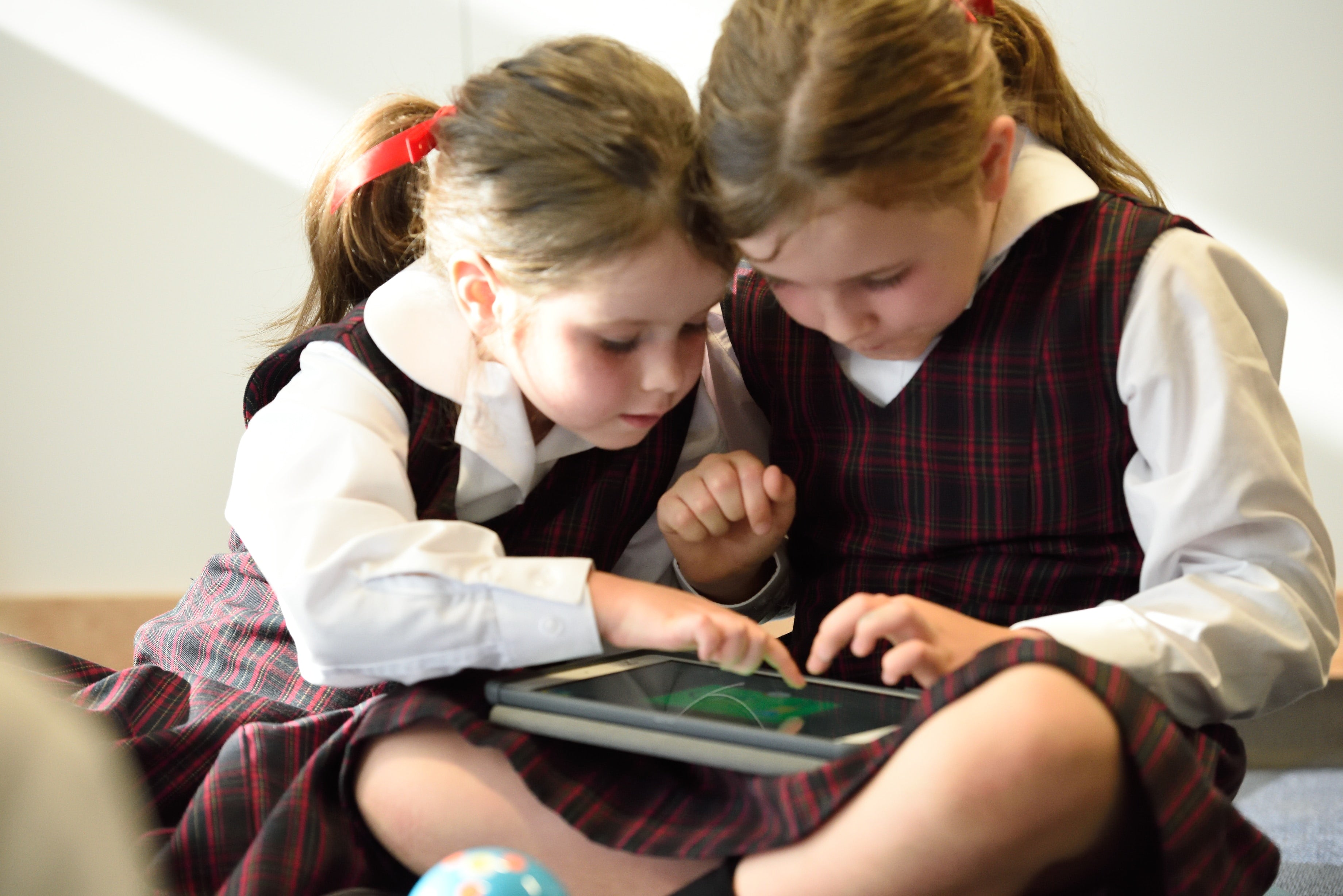 Two Sisters Playing on a Tablet Together - Sibling Photo Idea