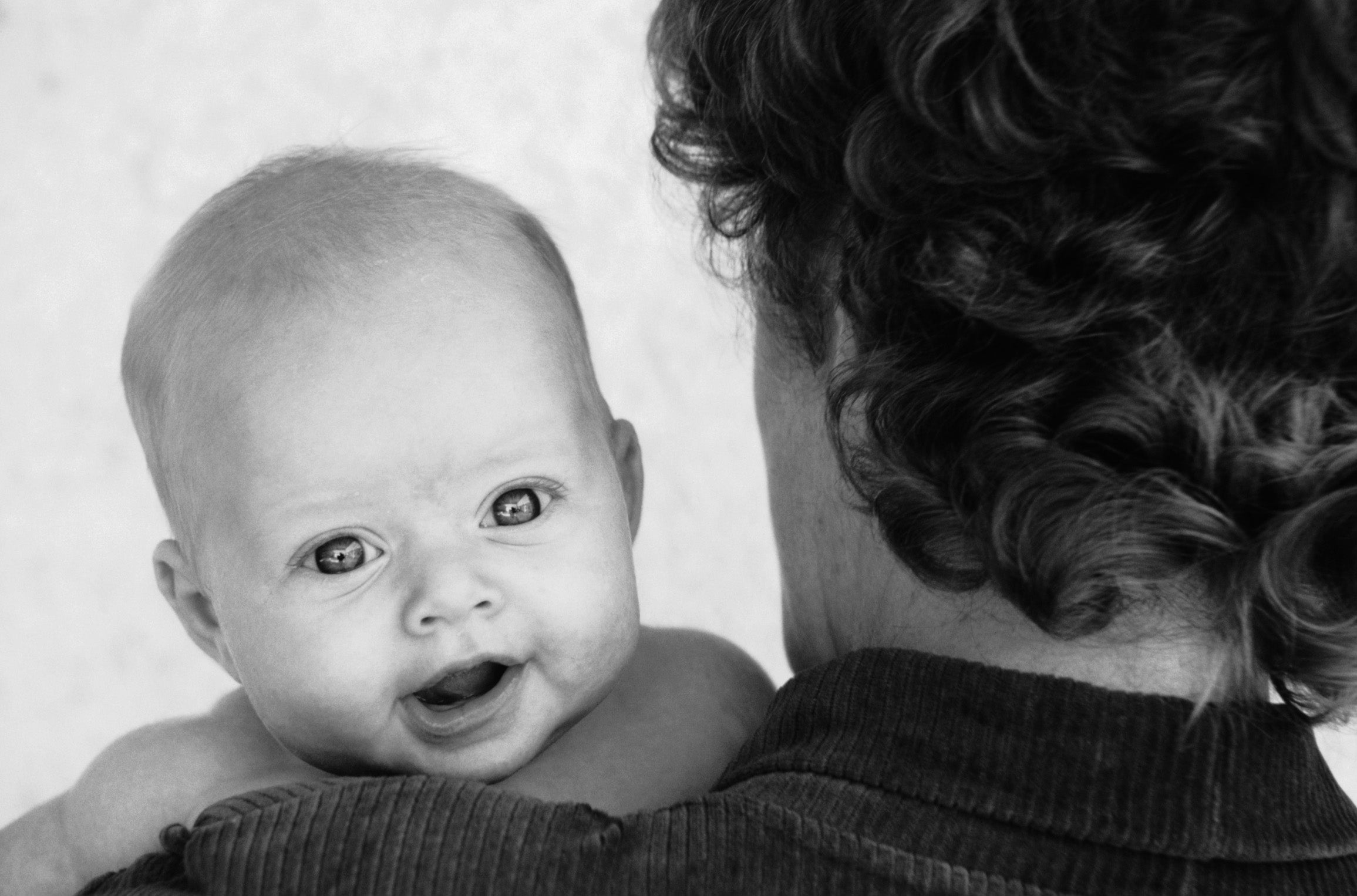 Baby looking over a person's shoulder