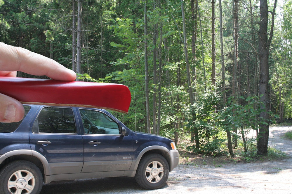 Forced Perspective photo of a person holding a canoe that looks miniature