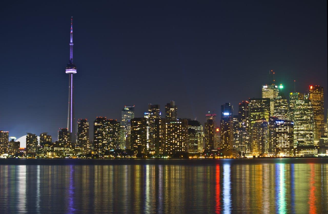 View of CN Tower at night with lights reflecting off water