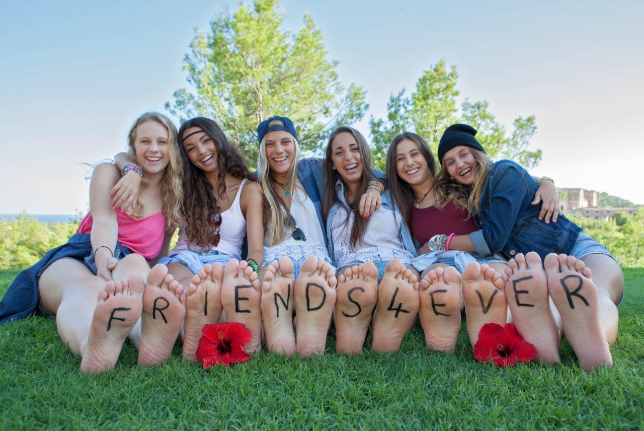 Outdoor group photo of girls with "friends4ever" written on their feet