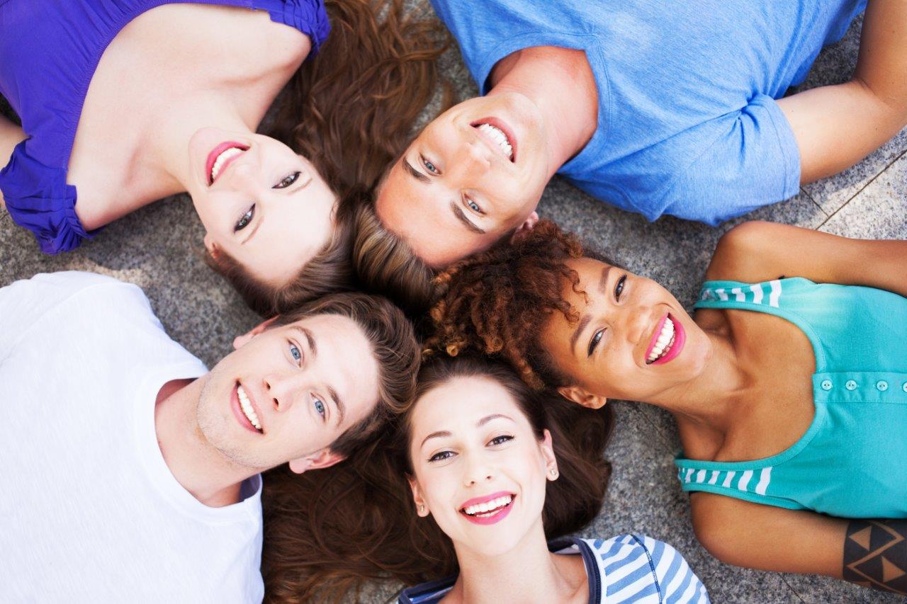 Group photo of friends laying in a circle