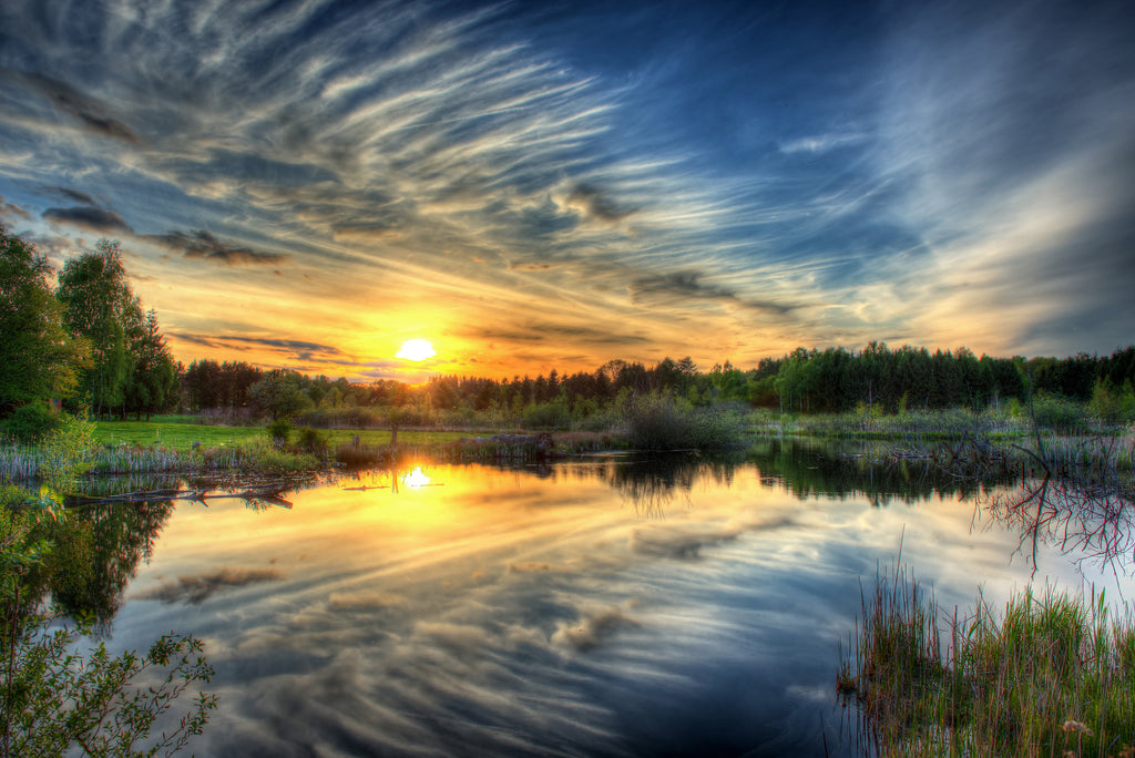 HDR landscape photo of sunset, clouds, and water reflection