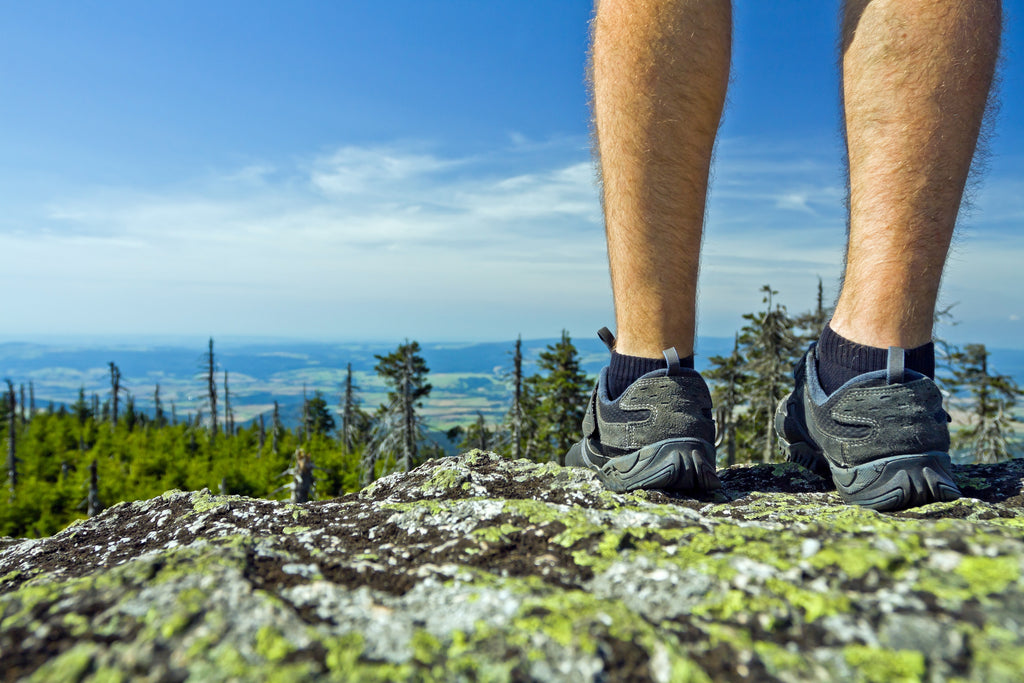 Landscape photo of a hiker on a mountain summit captured at a unique angle