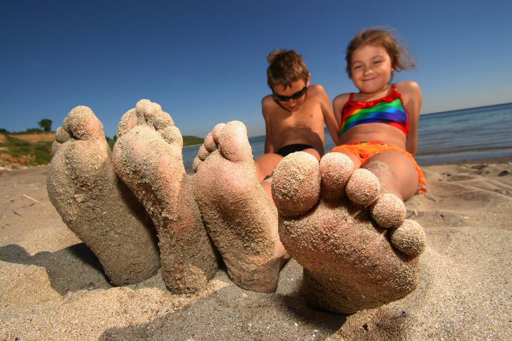 Kids on the beach with sandy feet