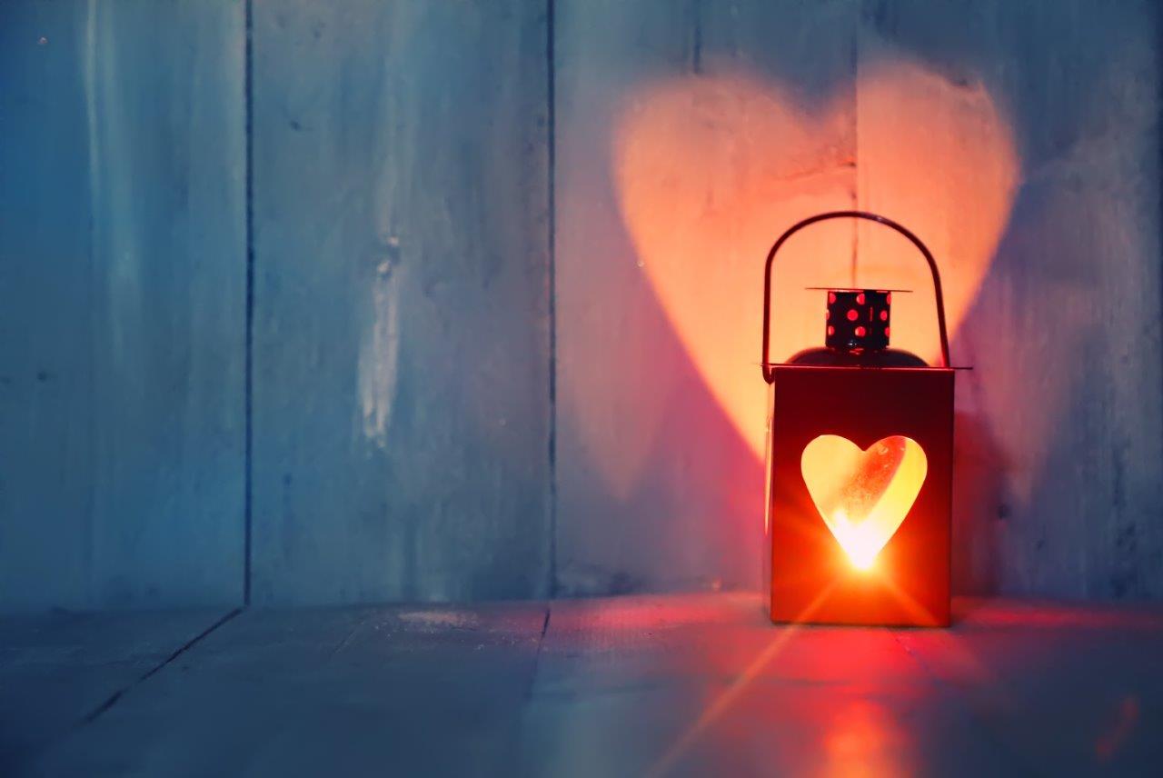 Low-light photo of a lantern reflecting light in the shape of a heart