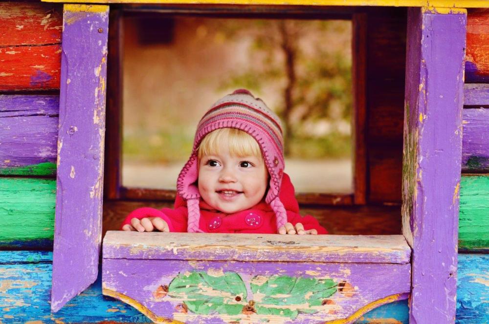 Little girl in a colourful playhouse as an example of creative compositional framing