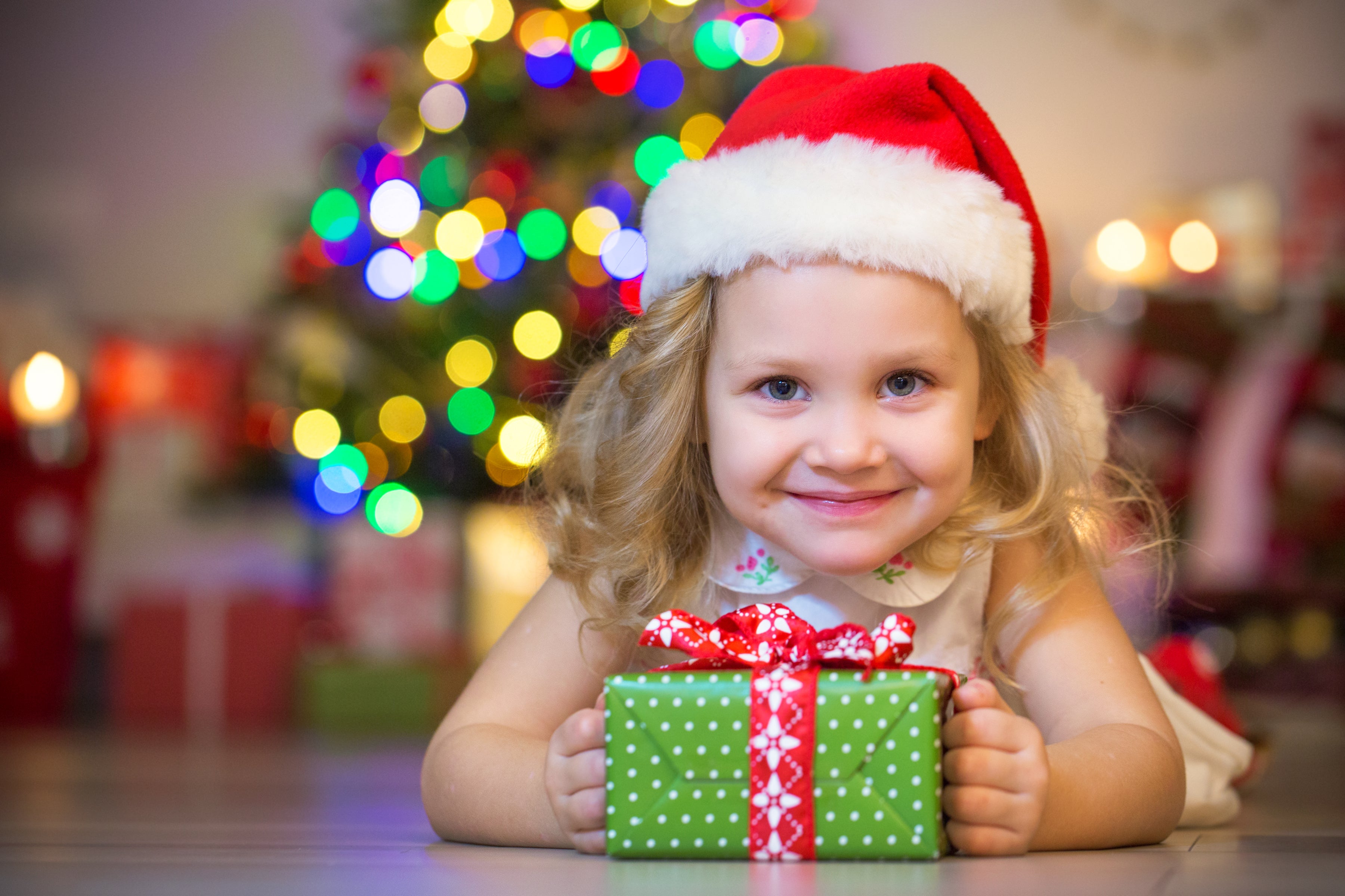 Holiday photo of a little girl excited to open her Christmas gift