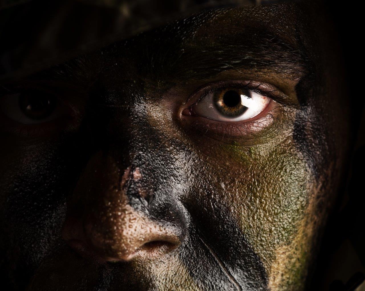 Close-up portrait of a man wearing camouflage face paint