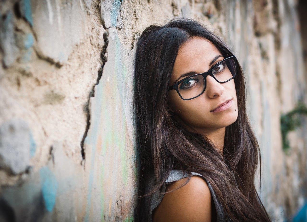 Portrait of a woman leaning up against a wall with texture