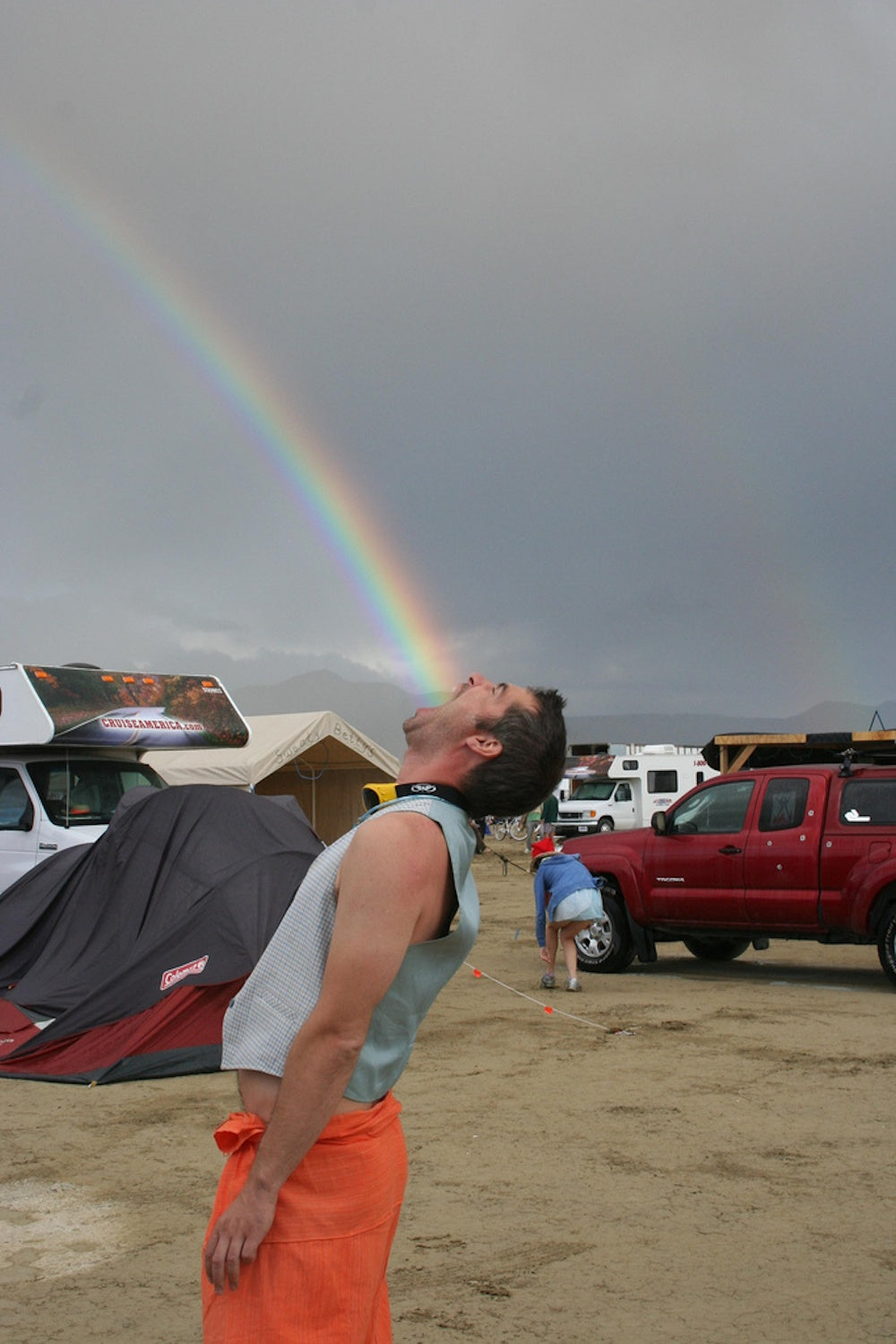 Forced perspective photo of a man eating a rainbow 