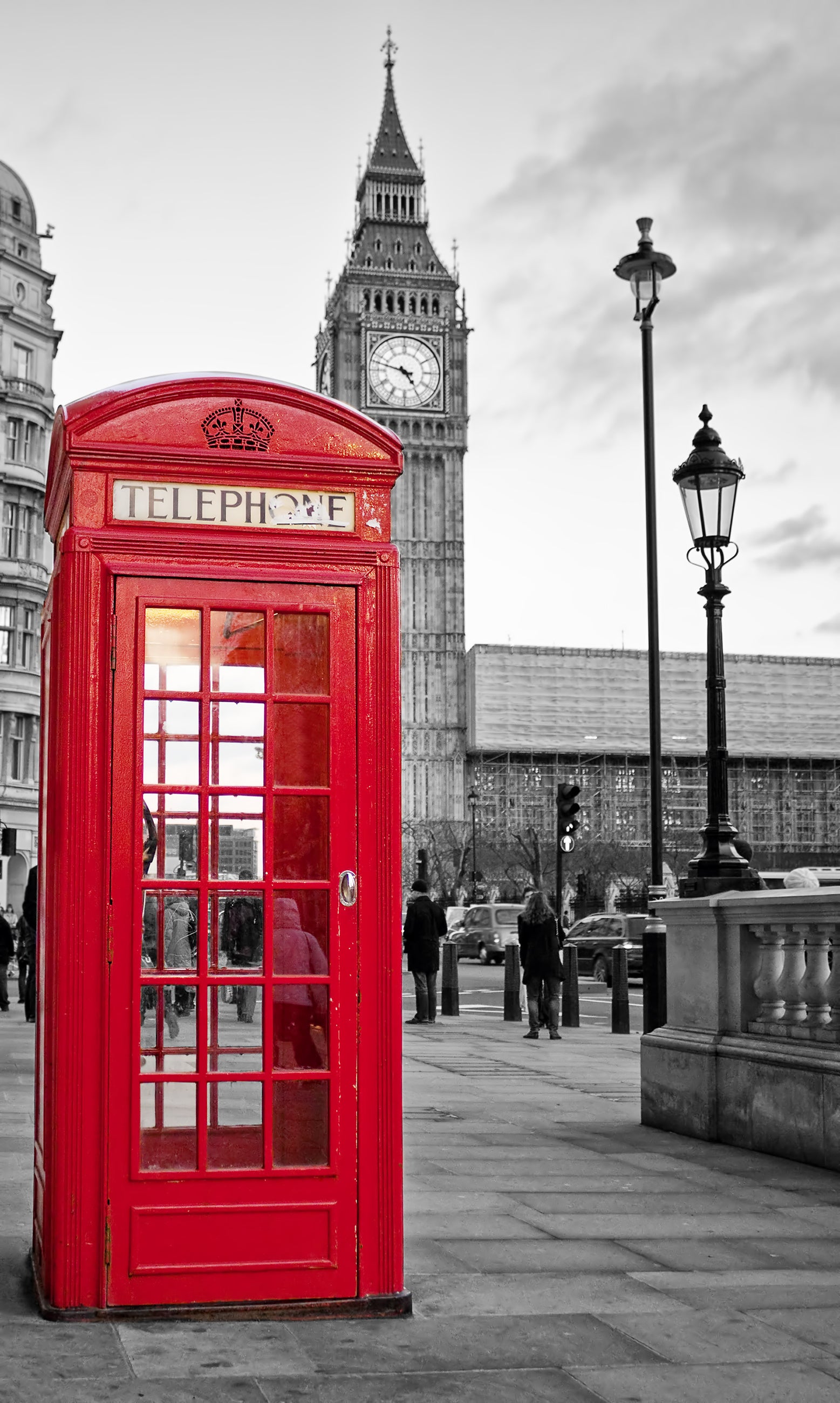 Traditional red phone booth in London with Big Ben clock tower in the background