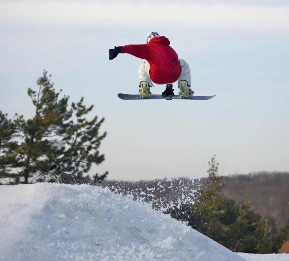 Snowboarder in the air with their arm illustrating the use of horizontal leading lines in photography