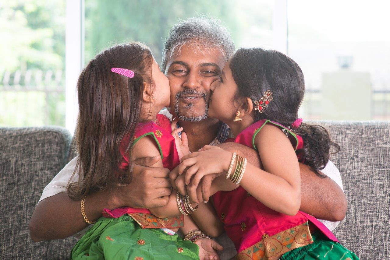 Man being kissed on the cheeks by two children