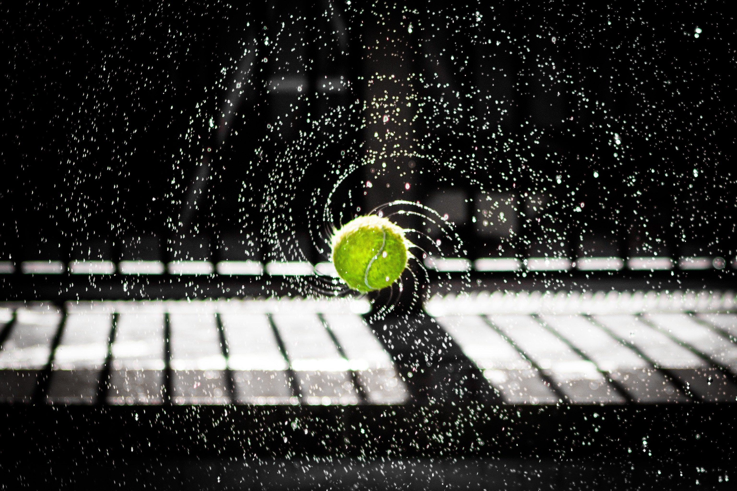 Water spraying from a tennis ball captured with a fast shutter speed